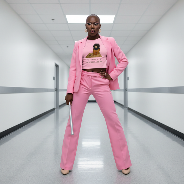 Front-facing model wears a pink graphic crop top under a pink suit, holding a silver baton