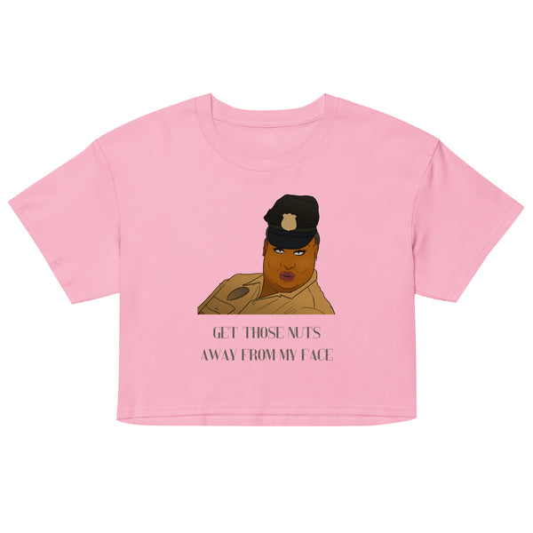 Front view of a pink crop top with a cartoon portrait and “GET THOSE NUTS AWAY FROM MY FACE” text
