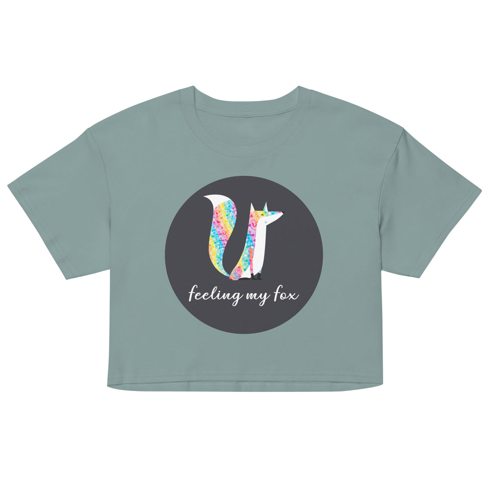 Front view of a sage green crop top with a colorful fox graphic and “feeling my fox” text