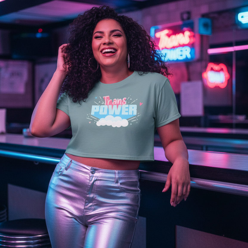 Person in a light green Trans Power crop top, embodying queer confidence, leans against a neon-lit counter. The top celebrates body positivity and self-expression, enhancing the vibrant, prideful scene.
