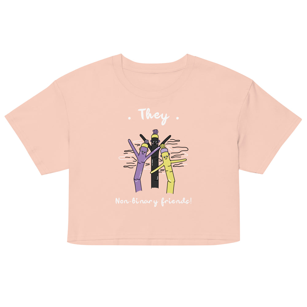 Front view of a peach crop top reading “They” and “Non-binary friends!” with colorful figures