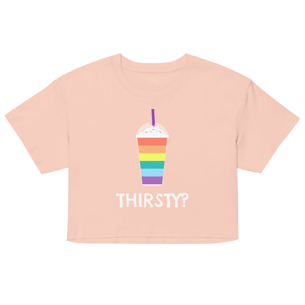 Front view of a peach crop top with a rainbow drink graphic and “THIRSTY?” text