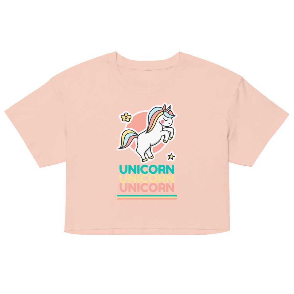Front-view peach crop top with a colorful leaping unicorn and repeated “UNICORN” text
