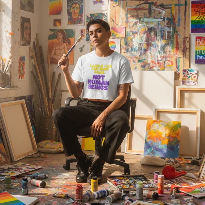Labels Are For Soup Cans" crop top worn by queer artist painting in a vibrant, colorful studio surrounded by art and supplies.