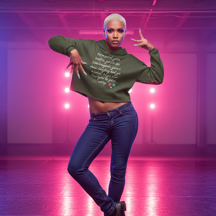 You Look Like Linda Evangelista olive green crop hoodie, styled by a short-haired femme in jeans; pink-purple stage lights behind her.