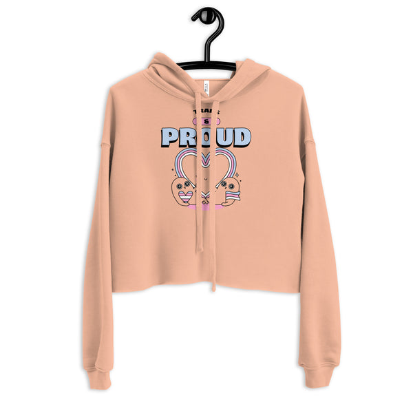 Cropped peach hoodie with TRANS & PROUD text and smiling characters forming a heart, celebrating transgender pride.