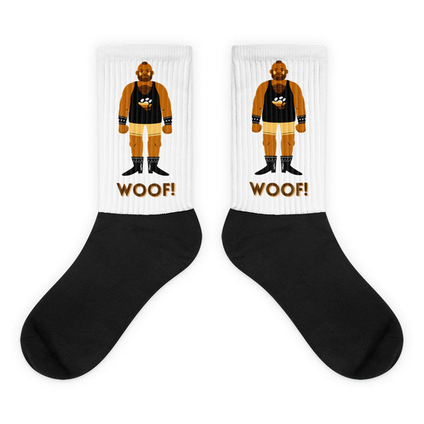 Pair of black-and-white crew socks with a muscle-man graphic and “WOOF!” text