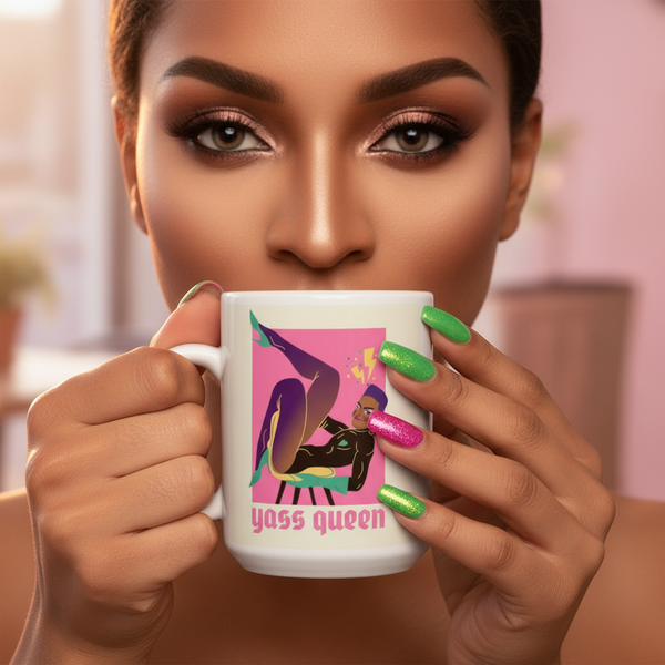 Person holds a white mug reading “yass queen,” with a colorful seated figure and bright green and pink nails
