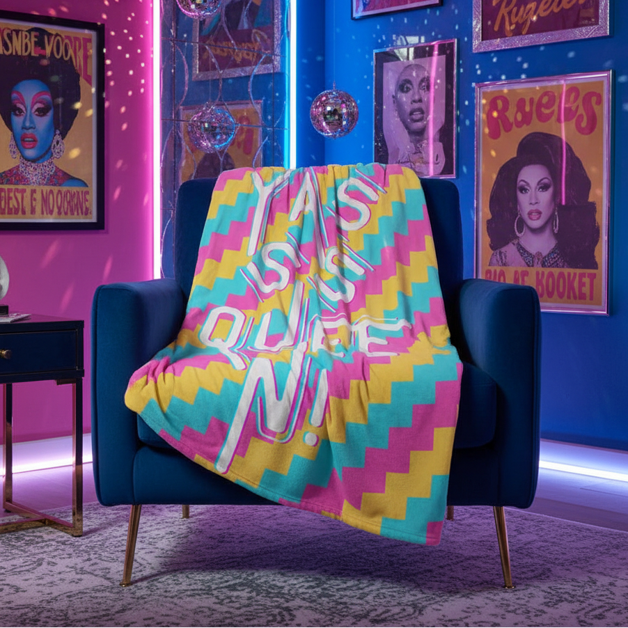 Yasss Queen Throw Blanket with "Don't Be a Drag, Just Be a Queen" and rainbow zigzags over navy chair, drag queen posters