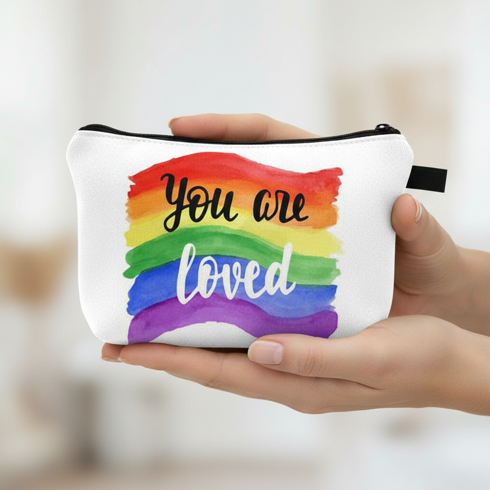 “You Are Loved Cosmetic Bag,” a white pouch with rainbow watercolor wash and “You are loved” in script