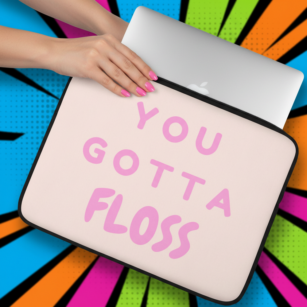 Laptop sleeve in light pink neoprene with bold pink “YOU GOTTA FLOSS” text, slid by a person with pink nails