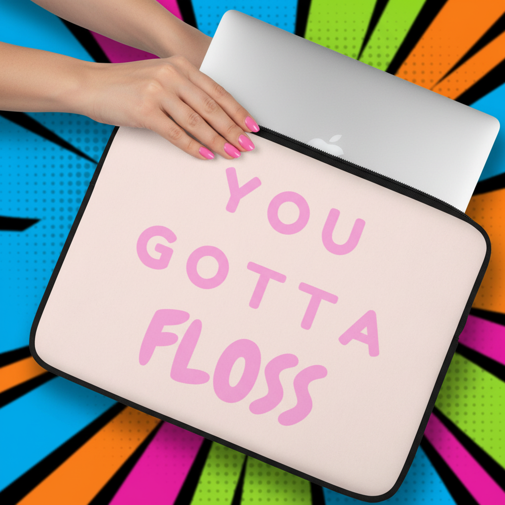 Laptop sleeve in light pink neoprene with bold pink “YOU GOTTA FLOSS” text, slid by a person with pink nails