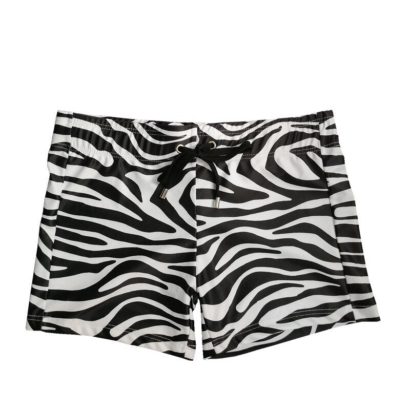 Front view of black-and-white zebra-print swim shorts with a drawstring waist