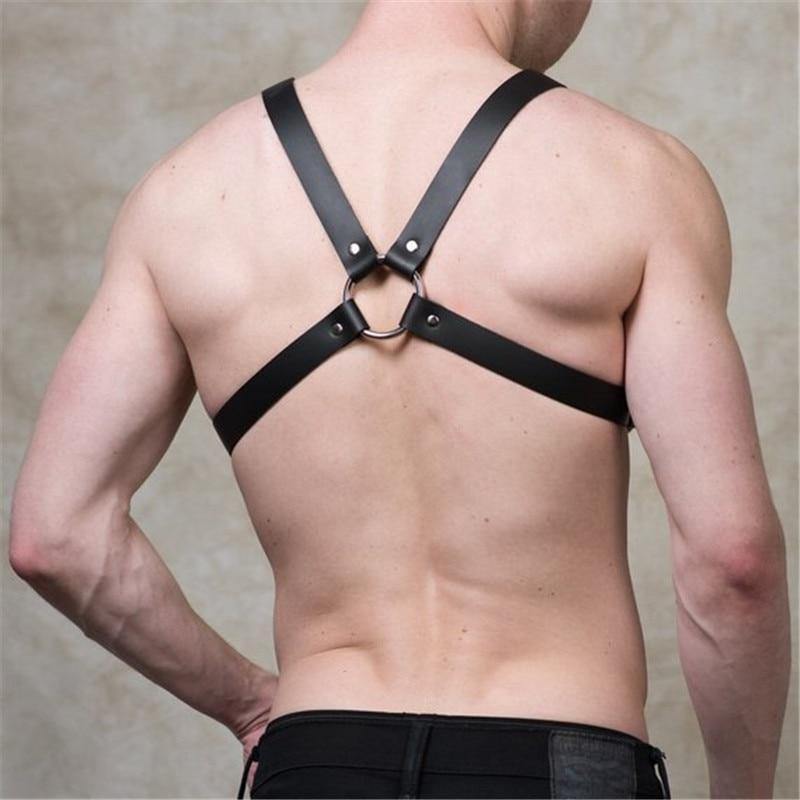 Rear view of a model wearing a black four-strap leather harness with metal O-rings