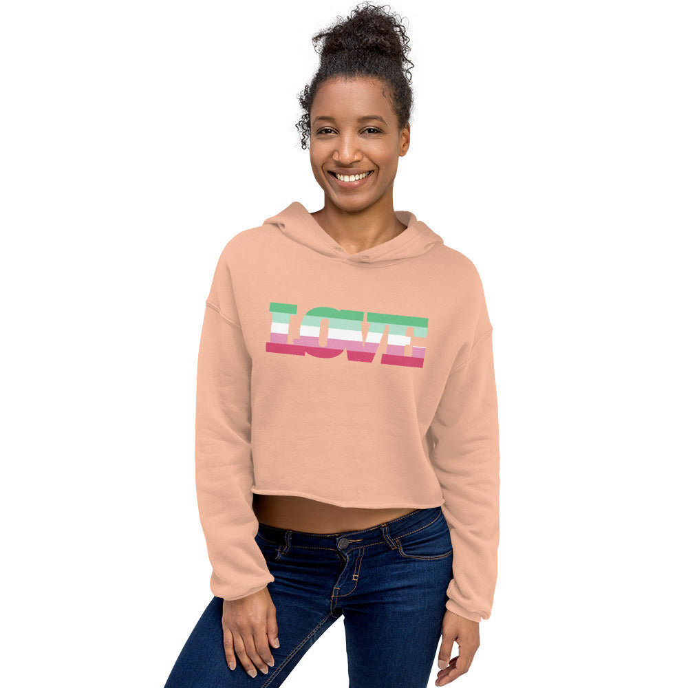 Front-view model wearing a peach cropped hoodie with a green, white, pink, and magenta stripe graphic
