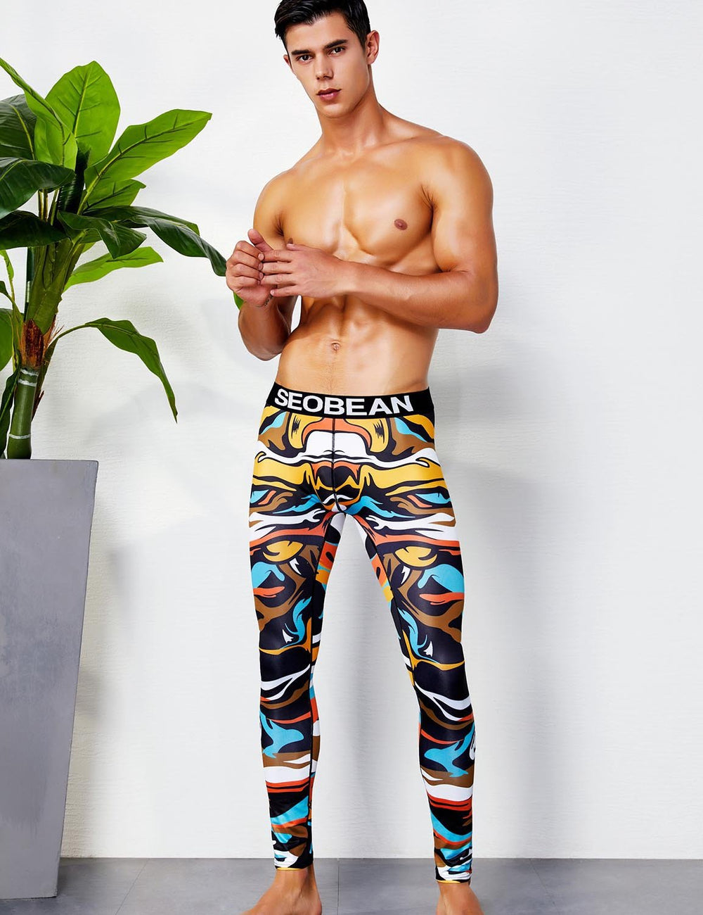 Colorful abstract-print leggings worn by a model, with a black SEOBEAN waistband