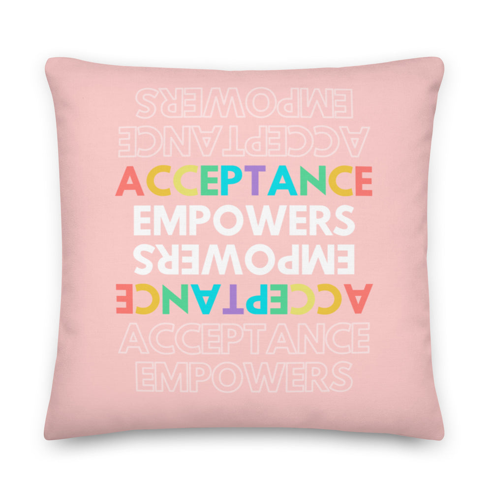Pink square pillow with colorful repeated “ACCEPTANCE EMPOWERS” text, some rotated upside down