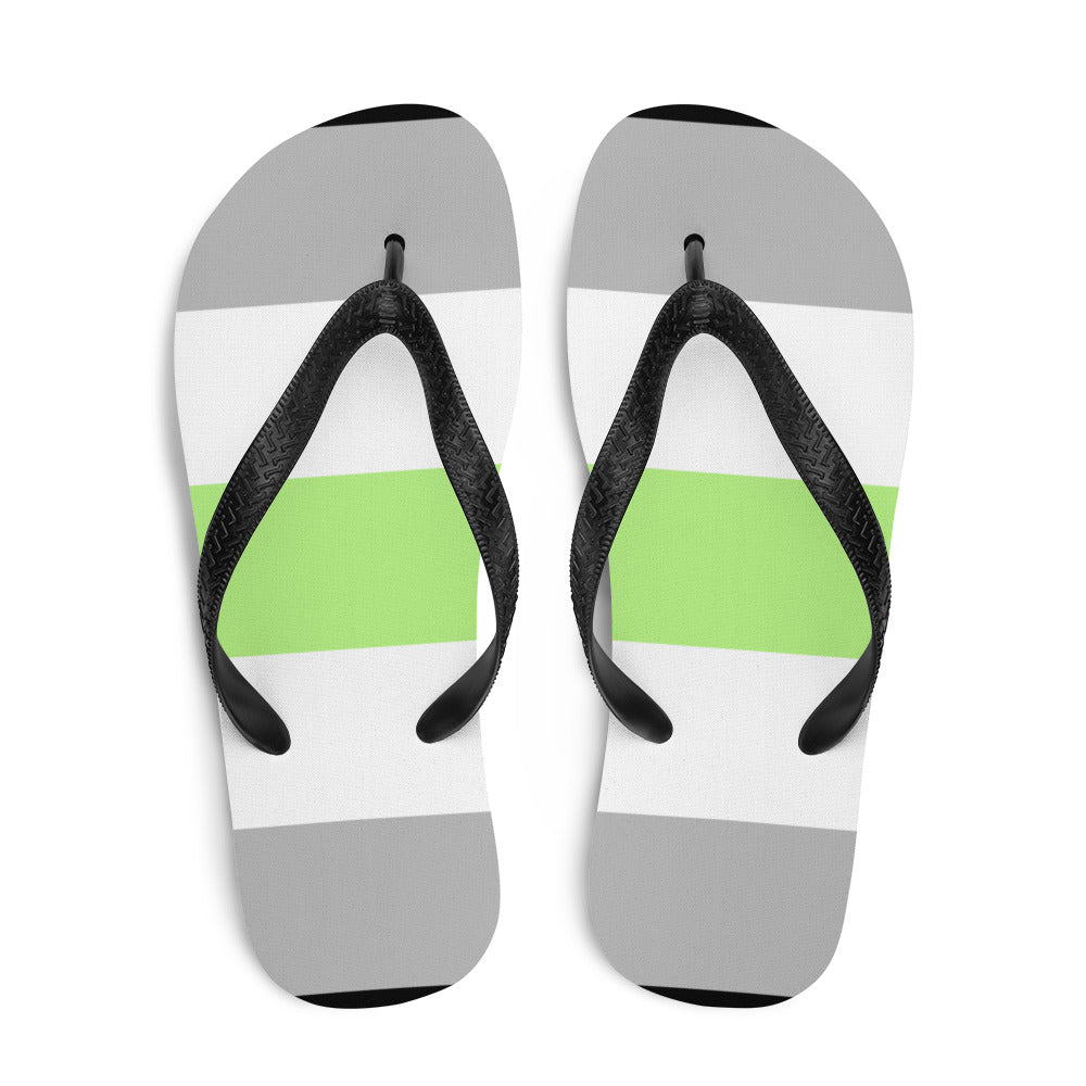 Pair of agender pride flip-flops shown from above with black straps and gray, white, and lime-green bands