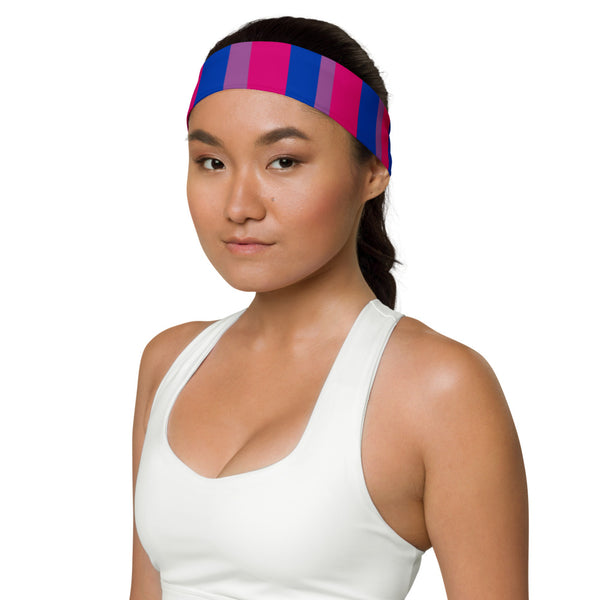 bi fan: A person with short curls and a soft smile wears a striped Bisexual Pride headband—pink, purple, blue