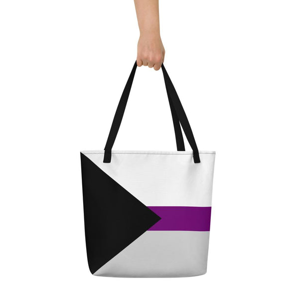 Black, white, gray, and purple striped tote bag held by one hand