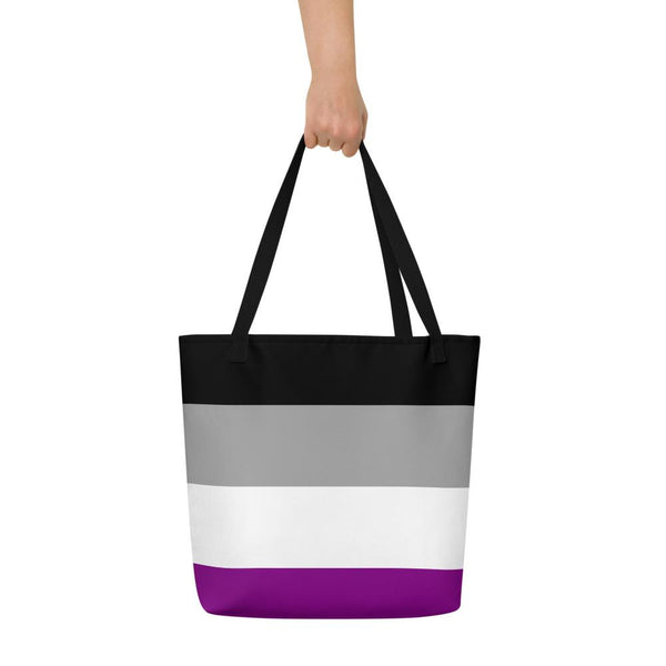Black tote bag with gray, white, and purple horizontal stripes, held by one hand