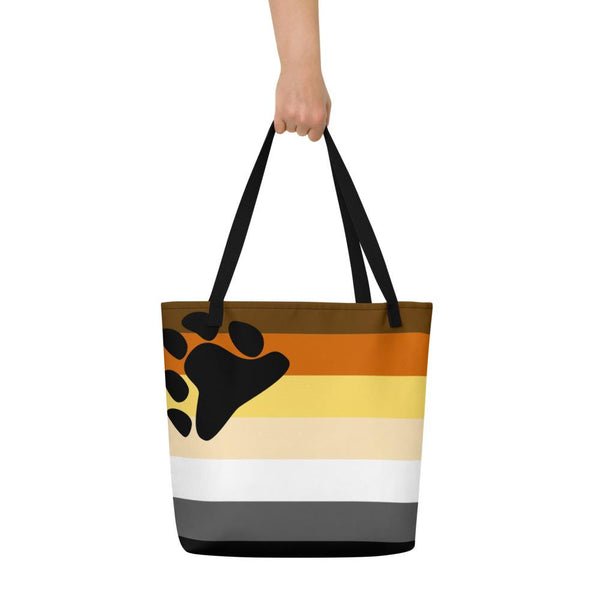 Front view of a black-handled tote with bear paw and brown, orange, cream, white, and black stripes