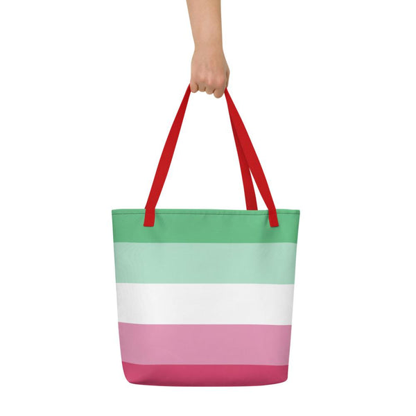 Abrosexual Pride striped tote bag with red handles, held up by one hand