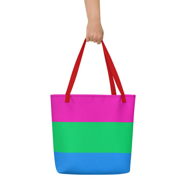 Front view of a color-block tote bag with pink, green, and blue panels and red handles