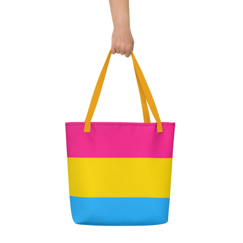 Front view of a pink, yellow, and blue striped tote bag with yellow handles