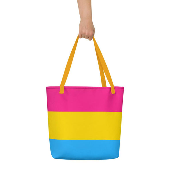 Front view of a pink, yellow, and blue striped tote bag with yellow handles