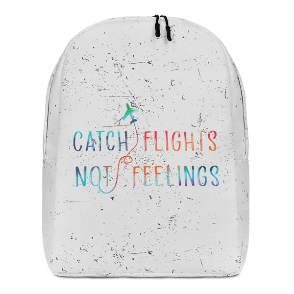 Front view of a white speckled backpack reading “CATCH FLIGHTS NOT FEELINGS” in rainbow lettering