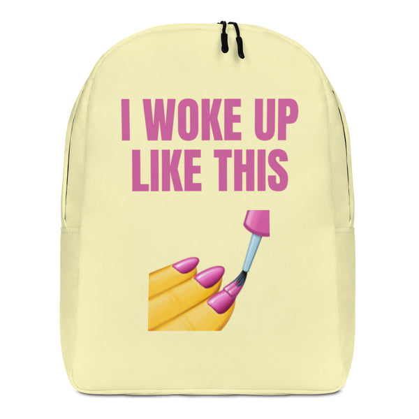Front view of a pale yellow backpack reading “I WOKE UP LIKE THIS,” with makeup graphics