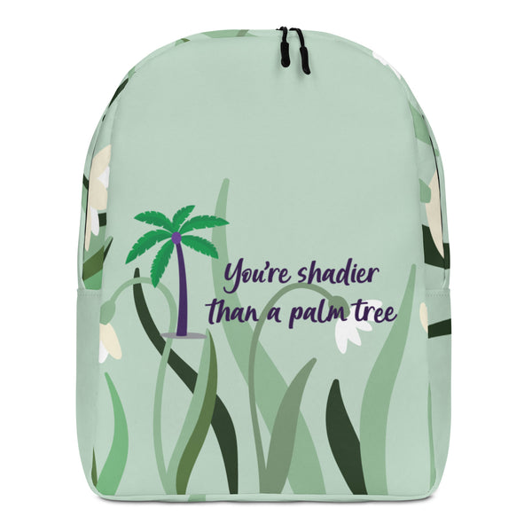 Front view of a pale green backpack with palm trees and the text “You’re shadier than a palm tree”