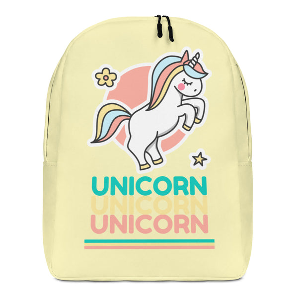 Front view of a pale yellow backpack with a colorful unicorn and repeated “UNICORN” text