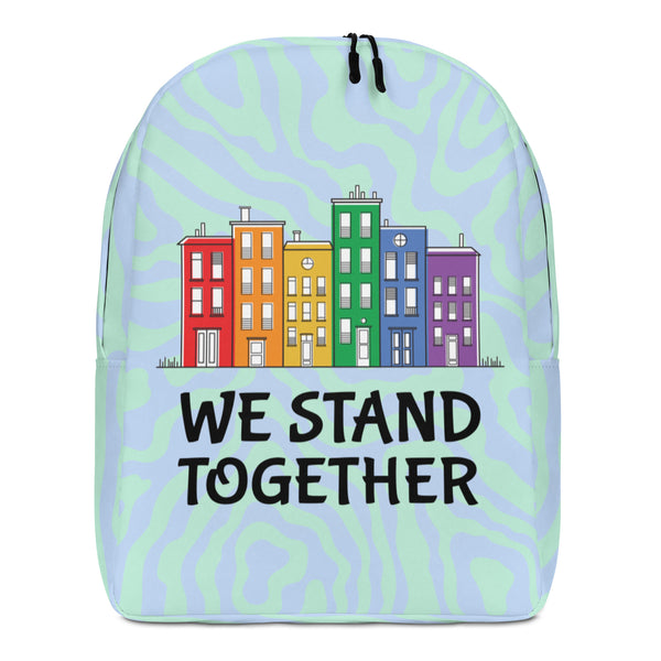 Front-facing pastel backpack with colorful row houses and “WE STAND TOGETHER” lettering