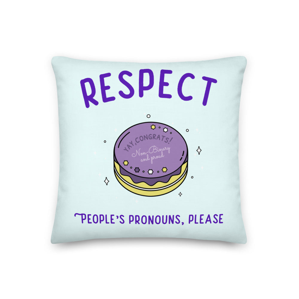 Light blue pillow reading “RESPECT PEOPLE’S PRONOUNS, PLEASE” with a nonbinary celebration cake