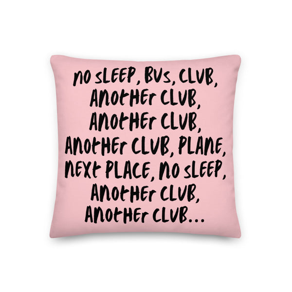 Pink pillow printed with the repeated phrase “NO SLEEP, BUS, CLUB, ANOTHER CLUB…”