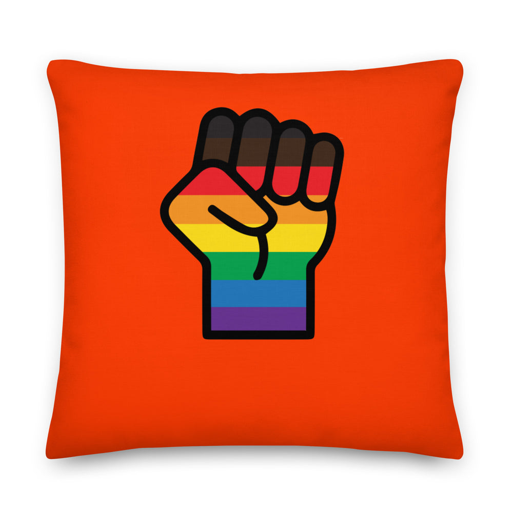 Front-facing orange square pillow with a raised fist filled with rainbow stripes
