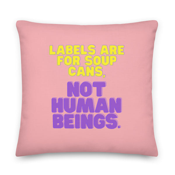 Square pink pillow with yellow and purple text reading “Labels Are for Soup Cans. Not Human Beings.”