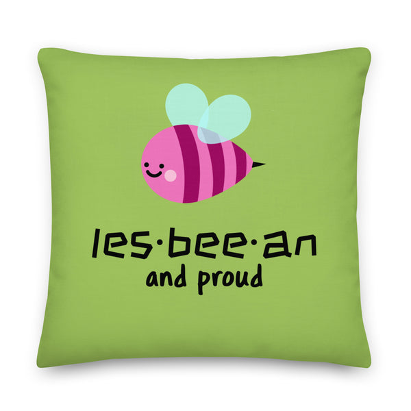 Green square pillow with a smiling pink bee and the words “les-bee-an and proud”