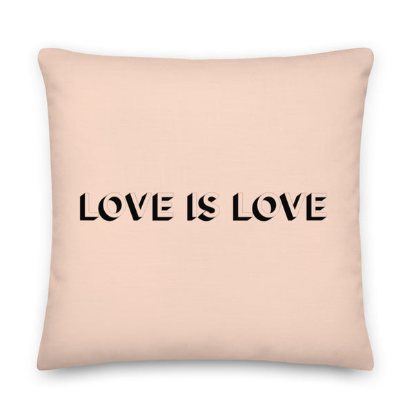 Front-facing pale pink square pillow reading “LOVE IS LOVE” in black lettering
