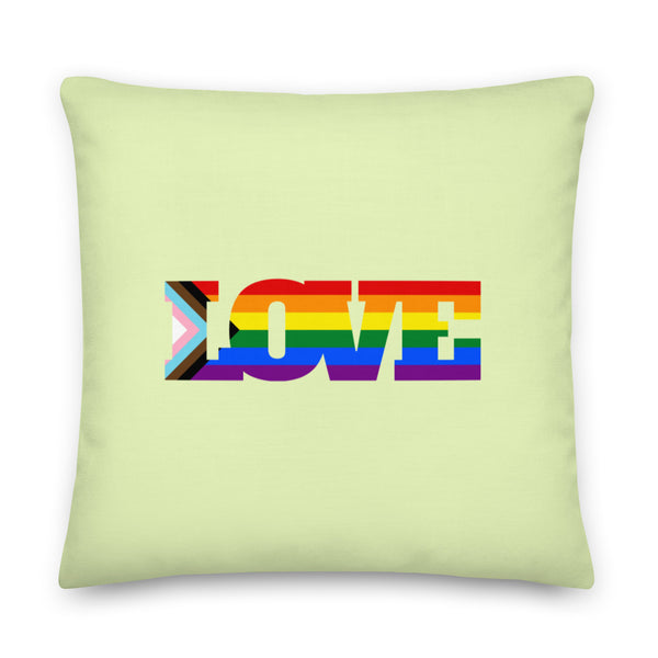 Light green square pillow with a rainbow-striped Progress Pride flag spelling “LOVE”