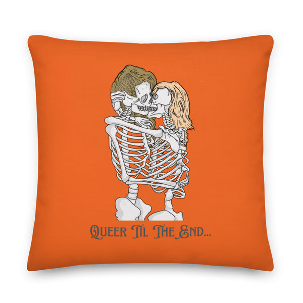 Orange square pillow showing two kissing skeletons and the words “QUEER TIL THE END...”