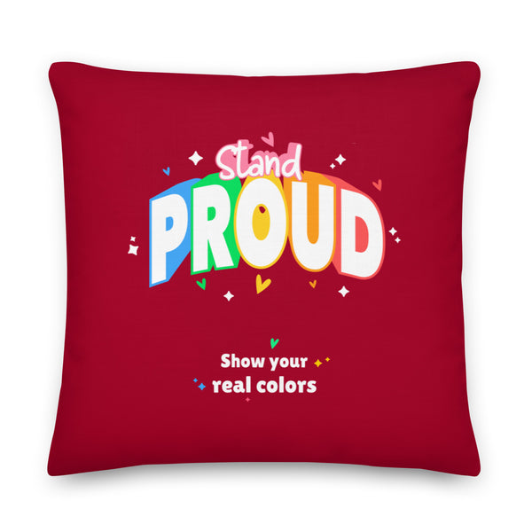 Square red pillow printed with “Stand Proud” and “Show your real colors”