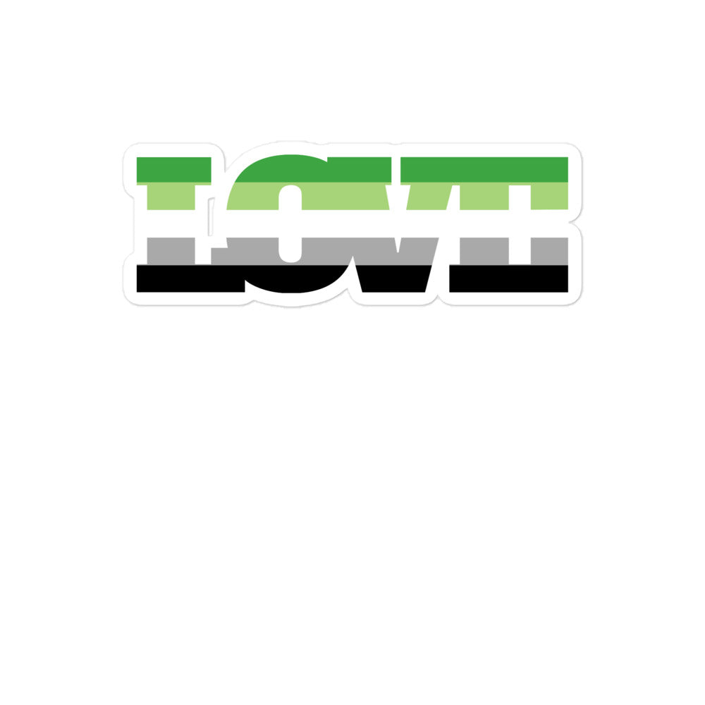 A die-cut sticker spelling “LOVE” in green, gray, and black block lettering