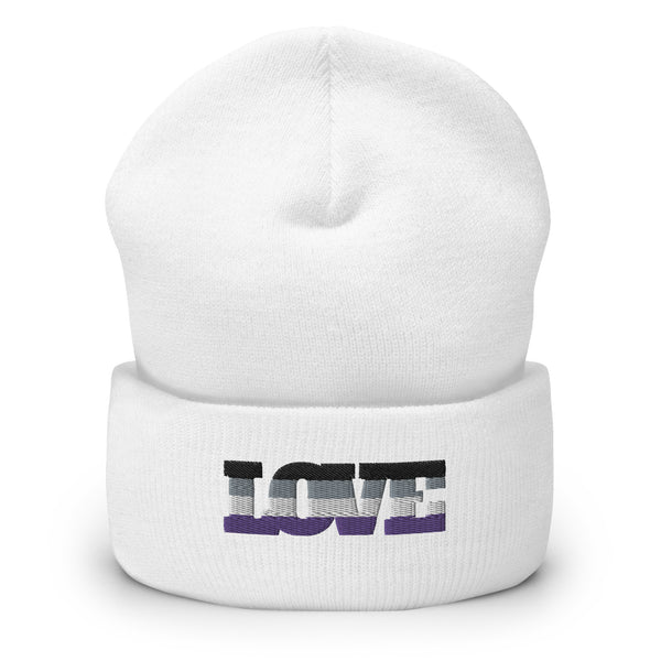 Front view of a white cuffed beanie with a pixelated black, gray, and purple wordmark