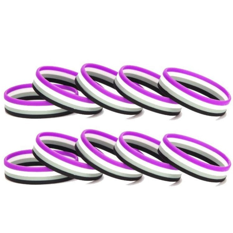 Ten purple, white, and black rubber wristbands arranged in two rows