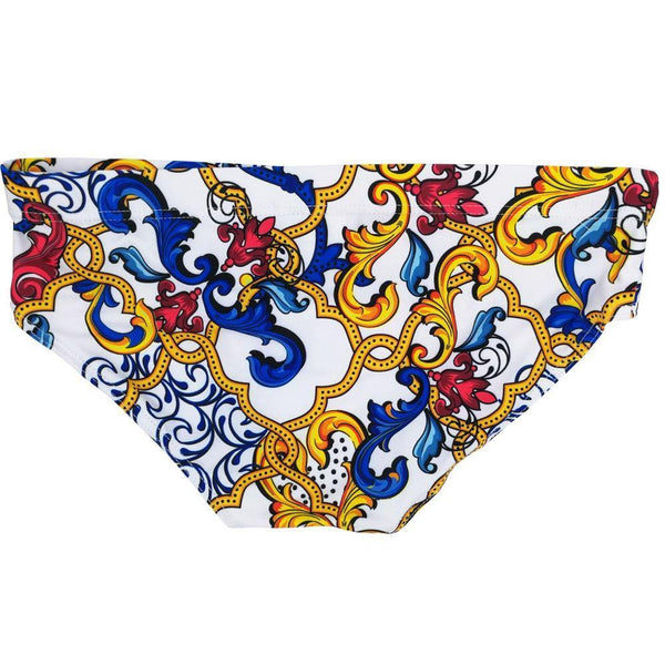 Close-up of white swim briefs with an ornate blue, red and yellow baroque scroll print