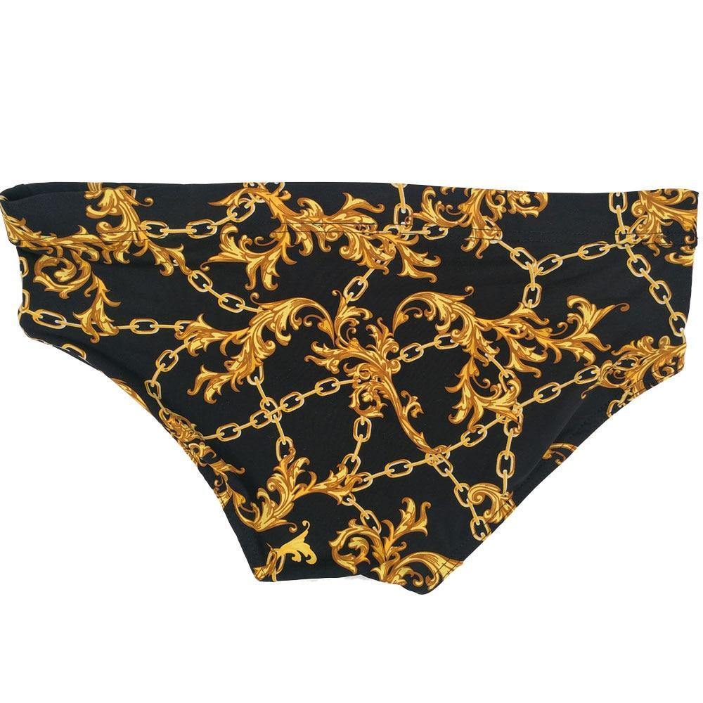 Black swim briefs with an ornate gold chain and baroque scrollwork print