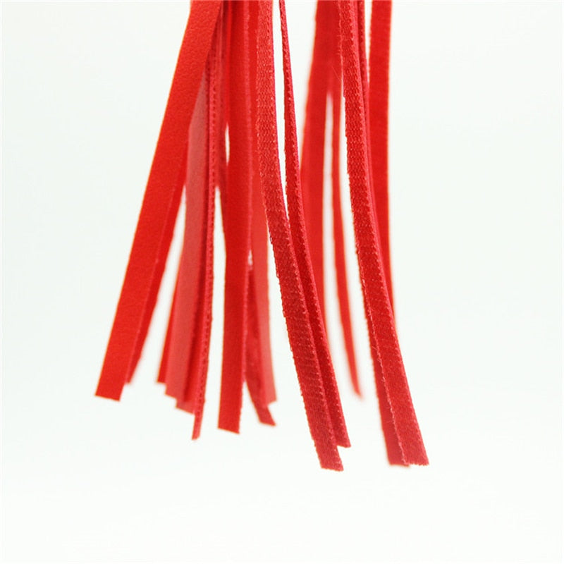 Close-up of multiple red whip strands against a white background